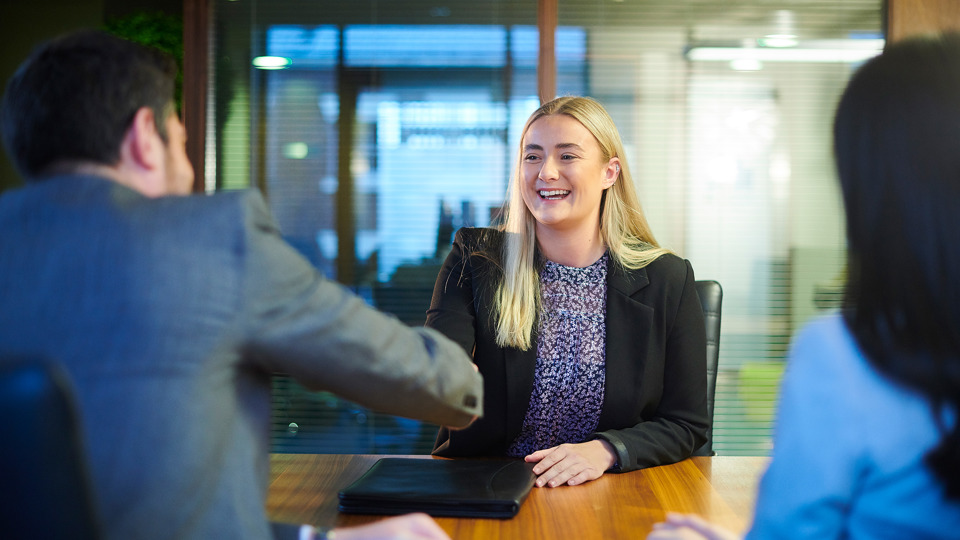 Woman shakes hand with interviewer